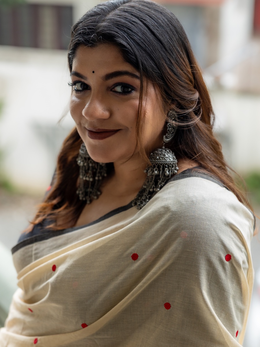 aparna-balamurali-in-classic-off-white-traditional-saree-embellished-with-delicate-red-polka-dot-motifs-and-a-contrasting-black-border-photos-005