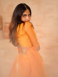 devika-sanjay-in-twirling-vivid-marigold-orange-lehenga-skirt-paired-with-a-matching-sheer-organza-dupatta-bordered-with-delicate-gold-lace-photos-001