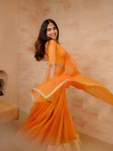 devika-sanjay-in-twirling-vivid-marigold-orange-lehenga-skirt-paired-with-a-matching-sheer-organza-dupatta-bordered-with-delicate-gold-lace-photos-002