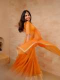 devika-sanjay-in-twirling-vivid-marigold-orange-lehenga-skirt-paired-with-a-matching-sheer-organza-dupatta-bordered-with-delicate-gold-lace-photos-002
