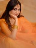 devika-sanjay-in-twirling-vivid-marigold-orange-lehenga-skirt-paired-with-a-matching-sheer-organza-dupatta-bordered-with-delicate-gold-lace-photos-005
