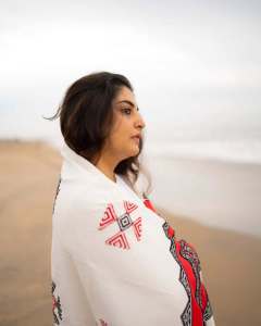 manjima-mohan-in-A-clean-minimal-all-white-solid-co-ord-set-featuring-a-long-sleeved-mid-length-tunic-kurta-with-matching-loose-fit-white-trousers-and-bold-red-and-black-shawl-002