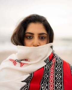 manjima-mohan-in-A-clean-minimal-all-white-solid-co-ord-set-featuring-a-long-sleeved-mid-length-tunic-kurta-with-matching-loose-fit-white-trousers-and-bold-red-and-black-shawl