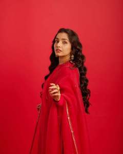rajisha-vijayan-in-vibrant-red-full-sleeve-flared-Anarkali-styling-with-Traditional-gold-jhumkas-and-statement-rings-photos-003