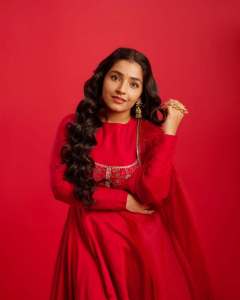 rajisha-vijayan-in-vibrant-red-full-sleeve-flared-Anarkali-styling-with-Traditional-gold-jhumkas-and-statement-rings-photos