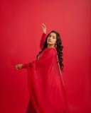 rajisha-vijayan-in-vibrant-red-full-sleeve-flared-Anarkali-styling-with-Traditional-gold-jhumkas-and-statement-rings-photos-006