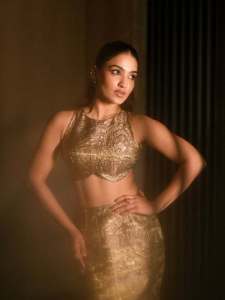 saniya-iyappan-in-high-waisted-floor-length-skirt-with-sleeveless-halter-style-crop-top-in-shimmering-metallic-gold-brocade-fabric-002