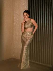 saniya-iyappan-in-high-waisted-floor-length-skirt-with-sleeveless-halter-style-crop-top-in-shimmering-metallic-gold-brocade-fabric-003