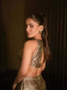 saniya-iyappan-in-high-waisted-floor-length-skirt-with-sleeveless-halter-style-crop-top-in-shimmering-metallic-gold-brocade-fabric-004