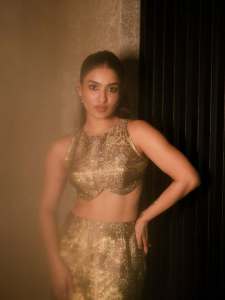 saniya-iyappan-in-high-waisted-floor-length-skirt-with-sleeveless-halter-style-crop-top-in-shimmering-metallic-gold-brocade-fabric-007