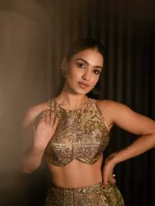 saniya-iyappan-in-high-waisted-floor-length-skirt-with-sleeveless-halter-style-crop-top-in-shimmering-metallic-gold-brocade-fabric