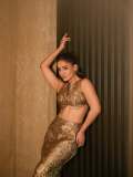 saniya-iyappan-in-high-waisted-floor-length-skirt-with-sleeveless-halter-style-crop-top-in-shimmering-metallic-gold-brocade-fabric-001
