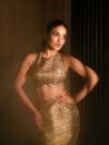 saniya-iyappan-in-high-waisted-floor-length-skirt-with-sleeveless-halter-style-crop-top-in-shimmering-metallic-gold-brocade-fabric-002