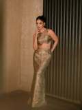 saniya-iyappan-in-high-waisted-floor-length-skirt-with-sleeveless-halter-style-crop-top-in-shimmering-metallic-gold-brocade-fabric-003