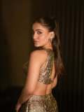 saniya-iyappan-in-high-waisted-floor-length-skirt-with-sleeveless-halter-style-crop-top-in-shimmering-metallic-gold-brocade-fabric-004
