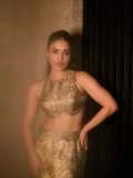 saniya-iyappan-in-high-waisted-floor-length-skirt-with-sleeveless-halter-style-crop-top-in-shimmering-metallic-gold-brocade-fabric-007