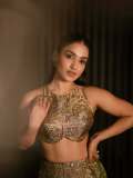 saniya-iyappan-in-high-waisted-floor-length-skirt-with-sleeveless-halter-style-crop-top-in-shimmering-metallic-gold-brocade-fabric