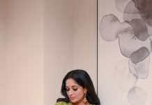 kavya madhavan in Soft wavy hair styled open paired with dangling ethnic earrings and a small blue bindi on her forehead photos