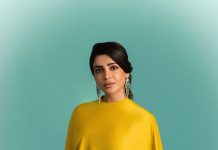 samantha ruth prabhu wearing a mustard yellow chartreuse ensemble featuring a high neckline and a draped cape like overlay that flows over her shoulders and down the right side of the dress