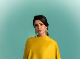 samantha ruth prabhu wearing a mustard yellow chartreuse ensemble featuring a high neckline and a draped cape like overlay that flows over her shoulders and down the right side of the dress