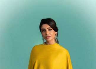 samantha ruth prabhu wearing a mustard yellow chartreuse ensemble featuring a high neckline and a draped cape like overlay that flows over her shoulders and down the right side of the dress