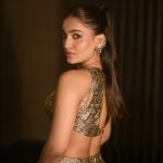 saniya iyappan in high waisted floor length skirt with sleeveless halter style crop top in shimmering metallic gold brocade fabric