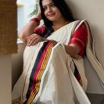 Floor sitting Kasavu saree pose with pleats spread