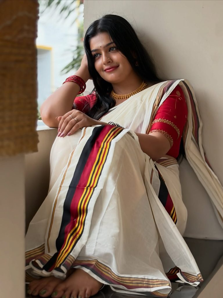 Floor sitting Kasavu saree pose with pleats spread