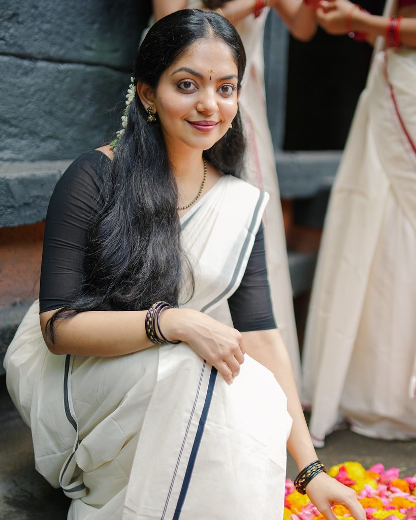 Modern minimalist sitting pose in Kerala Kasavu saree