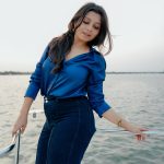 niranjana anoop in vibrant royal blue long sleeved button down shirt and High waisted wide leg dark wash jeans photos