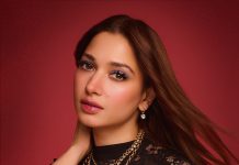 tamanna in floor length black gown featuring a high mock neckline and an intricate sheer lace bodice panel design outfit
