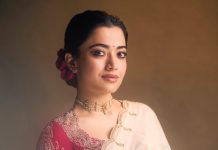 rashmika mandanna in cream colored saree with pink long sleeved blouse adorned with rich intricate gold paisley and floral embroidery design photos