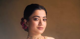 Rashmika Mandanna rashmika mandanna in cream colored saree with pink long sleeved blouse adorned with rich intricate gold paisley and floral embroidery design photos